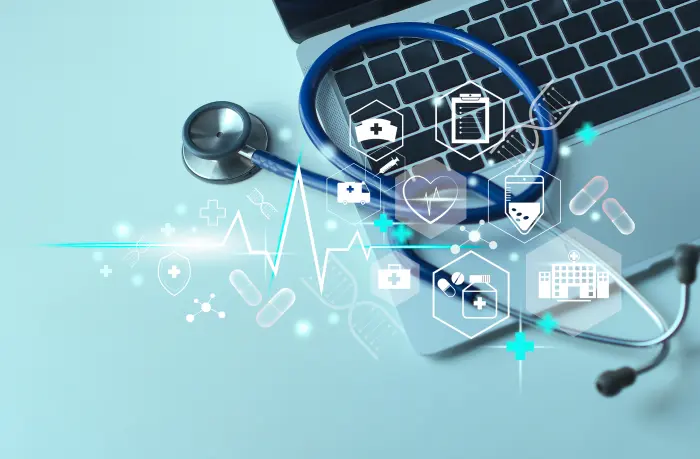 Stethoscope resting on a laptop surrounded by illustrated hospital, pharmacy and patient care icons